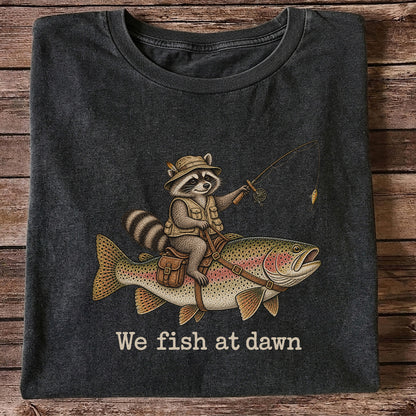 We Fish at Dawn Raccoon Riding a Rainbow Trout Fishing T-Shirt