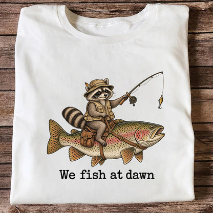 We Fish at Dawn Raccoon Riding a Rainbow Trout Fishing T-Shirt