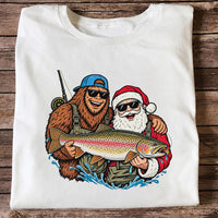 Bigfoot and Santa Holding Rainbow Trout Christmas Fishing Graphic T-Shirt