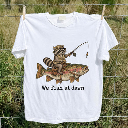We Fish at Dawn Raccoon Riding a Rainbow Trout Fishing T-Shirt